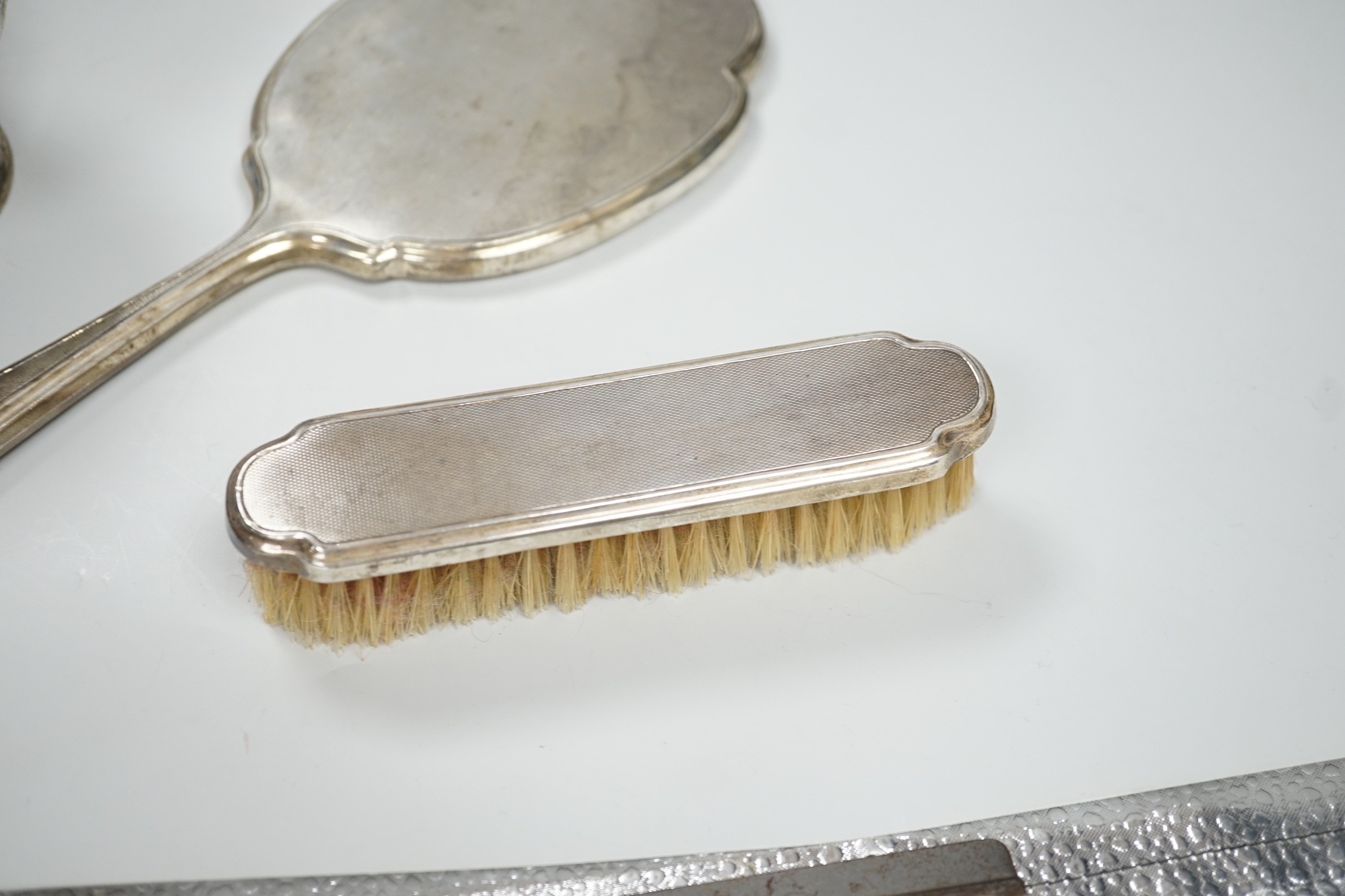 An Edwardian demi-fluted silver small presentation pedestal bowl, Sheffield, 1904, diameter 10.9cm and a silver mounted hand mirror and clothes brush.